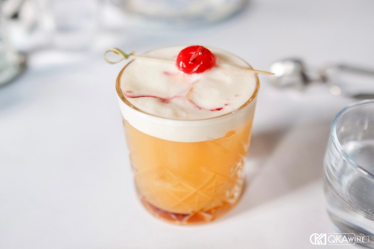 Amaretto Sour màu hổ phách trong ly rocks trên đá