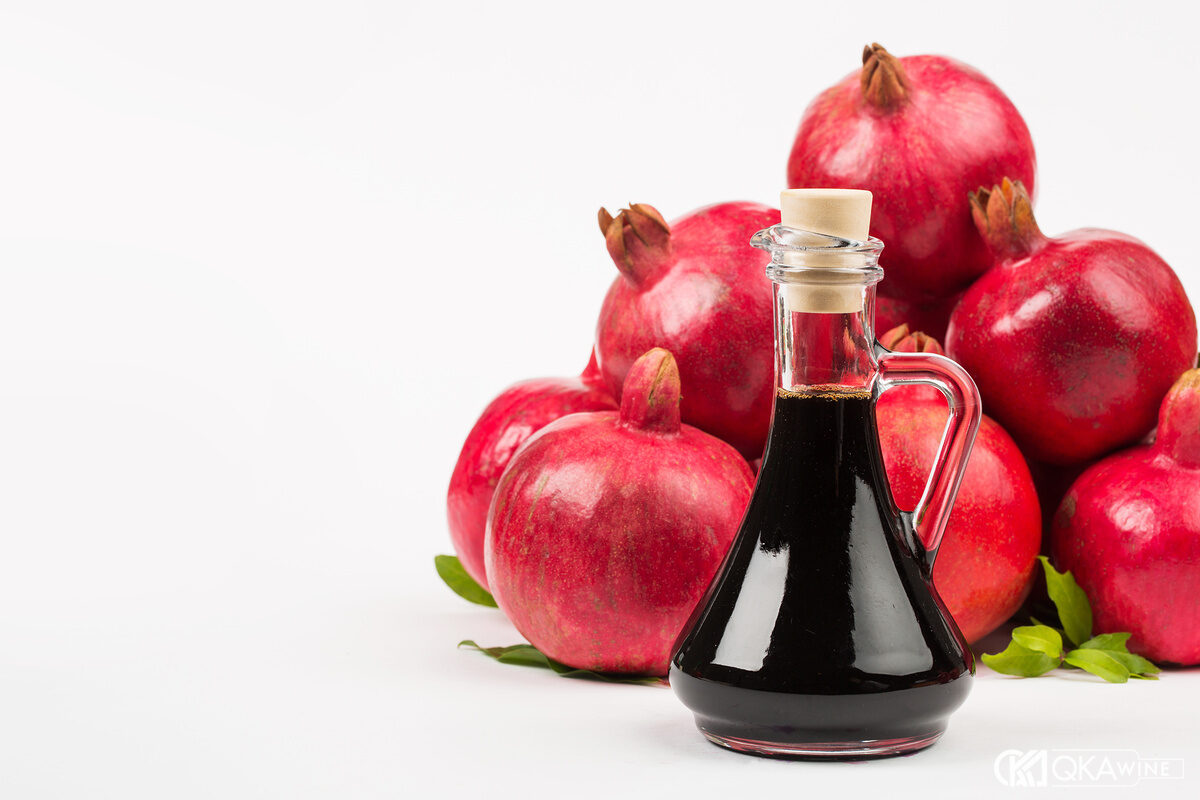 Grenadine đỏ trong chai cùng lựu và dụng cụ đong