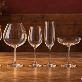 Sáu dáng ly rượu vang trong suốt trên bàn gỗ ngược sáng