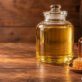 Bình rượu màu vàng cạnh chai mật và miếng tổ ong dùng làm đạo cụ