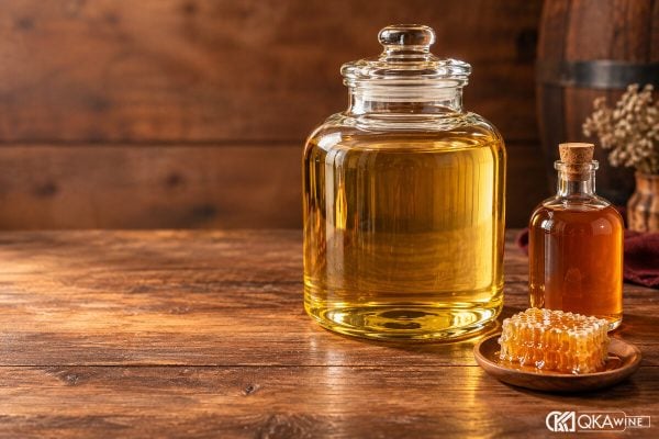 Bình rượu màu vàng cạnh chai mật và miếng tổ ong dùng làm đạo cụ