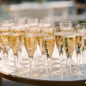 Những ly vang sủi xếp sẵn trên bàn tròn đón khách ngoài trời
