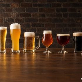 Sáu ly các loại bia từ vàng nhạt tới đen trên quầy gỗ