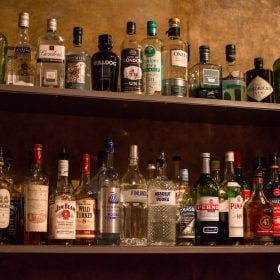 Kệ quầy bar bày các loại rượu mạnh và rượu mùi