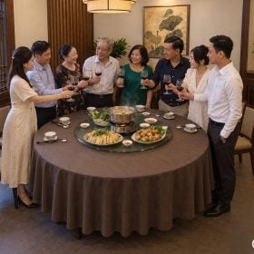 Người lớn mời rượu và nâng ly vang quanh bàn tròn Việt Nam