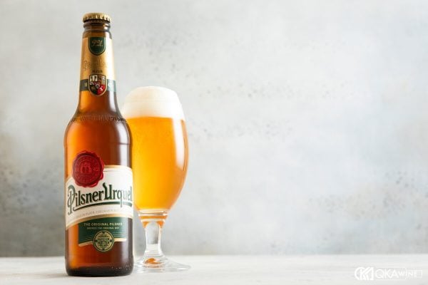Chai Pilsner Urquell cạnh ly bia vàng phủ bọt trắng
