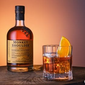 Chai Monkey Shoulder cạnh ly rocks có đá và lát cam