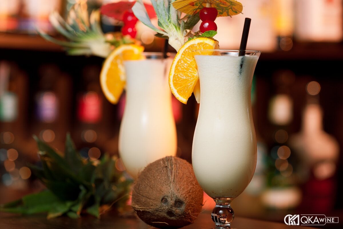 Hai ly Piña Colada trắng kem trang trí cam và dứa trên quầy bar