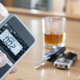 Máy đo nồng độ cồn cạnh ly rượu và chìa khoá xe