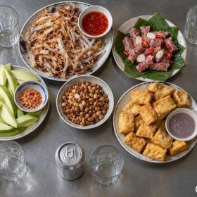 Bàn món nhậu Việt nhìn từ trên với mực, nem, lạc, bia