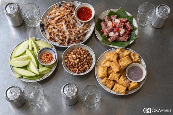 Bàn món nhậu Việt nhìn từ trên với mực, nem, lạc, bia