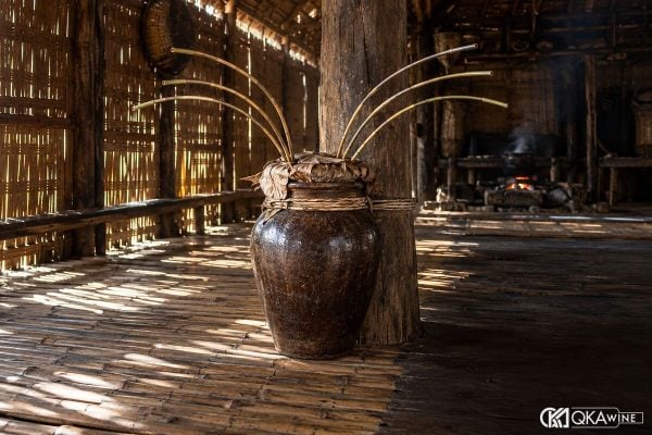 Ché rượu cần gốm nâu cắm nhiều cần trúc trong nhà sàn