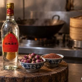 Chai rượu Mai Quế Lộ cạnh nụ hồng khô và bát cao lương