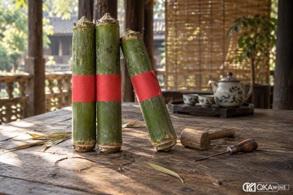 Ba ống rượu tre xanh nhãn đỏ dựng cạnh búa gỗ nhỏ