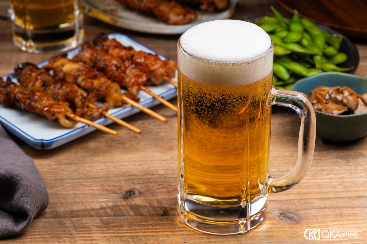 Đĩa xiên gà nướng yakitori cạnh cốc bia ở quán izakaya